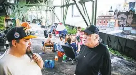  ?? Andrew Rush/Post-Gazette ?? Jack Brumbaugh, left, with Blankets Over Pittsburgh talks to John Flint, who lives in a tent camp under a bridge on the South Side.