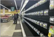  ?? PARKER PURIFOY — THE ASSOCIATED PRESS ?? Shoppers walk past empty aisles of produce at a Safeway on Tuesday in Washington.
