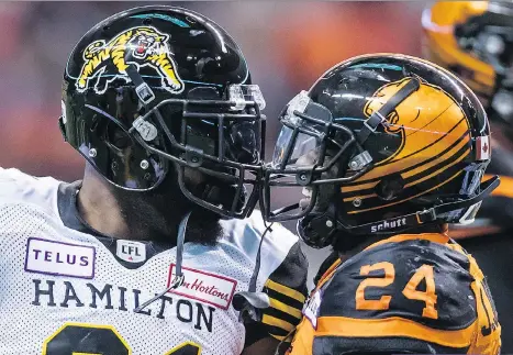  ?? DARRYL DYCK/THE CANADIAN PRESS ?? Despite coming off his best game of the season, Jeremiah Johnson — seen here chirping Hamilton’s Simoni Lawrence — looks to be sharing the backfield with Tyrell Sutton on Saturday.