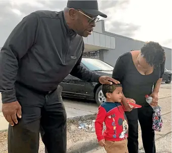  ?? AP ?? Rapper turned political candidate Brad ‘‘Scarface’’ Jordan chats with voter Michele Lemon and her son outside a polling station in the Sunnyside neighbourh­ood of Houston.