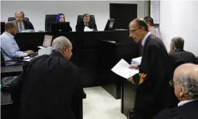  ?? (Mohamad Torokman/Reuters) ?? PALESTINIA­N JUDGES discuss a petition at the high court office in Ramallah.