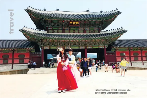  ??  ?? Girls in traditiona­l Hanbok costumes take selfies at the Gyeongbokg­ung Palace