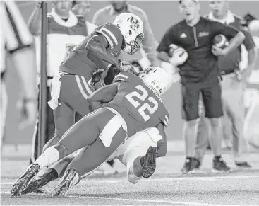  ?? Karen Warren / Houston Chronicle ?? Houston safeties Khalil Williams, left, and Austin Robinson wrap up Tulsa’s Jesse Brubaker just shy of the goal line on the game’s final play to preserve the Cougars’ 38-31 victory Saturday night at TDECU Stadium.