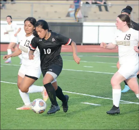  ?? Bennett Horne/Special to McDonalD county preSS ?? Lady Mustang sophomore Keisha roponei (10) dribbles between two neosho defenders tuesday night
during McDonald county’s 4-3 loss in double overtime.
