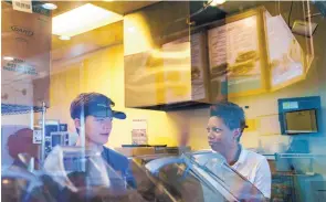  ?? CAROLYN KASTER/ASSOCIATED PRESS ?? Nicole Drake, co-owner of Tropical Smoothie Cafe franchises in Gainesvill­e and Ashburn, Va., talks with employee Matthew Dumm in the Ashburn store.