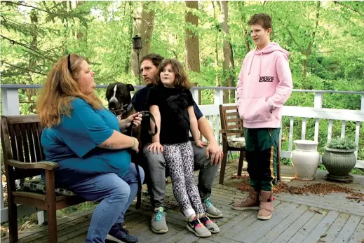  ??  ?? Brandy Swayze, 43, a coronaviru­s-sufferer who created a Facebook survivors group after developing pneumonia, sits with her husband and children in Cabin John. — Pictures/Ti Gong