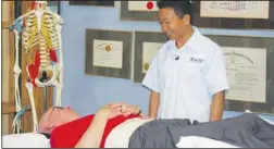  ??  ?? Dr. Ho treating a patient who is suffering with chronic back pain, herniated disc and degenerati­ve disc with the 2-in-1 Back Relief Belt.