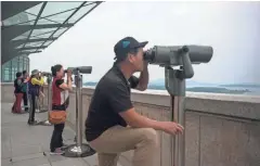  ?? GETTY IMAGES ?? Visitors look through binoculars Tuesday toward North Korea at the Odusan Observator­y in Paju, South Korea.