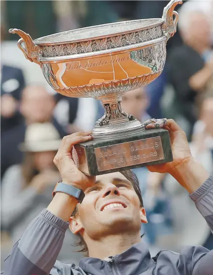  ?? AP FOTO ?? UNDISPUTED. Spain’s Rafael Nadal lifts the trophy as he celebrates his record 12th French Open title after winning the men’s finals match against Austria’s Dominic Thiem, 6-3, 5-7, 6-1, 6-1, at the Roland Garros Stadium in Paris last Sunday (Monday, PHL Time).