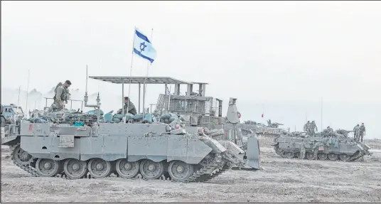  ?? Gil Cohen-magen Tribune News Service ?? Israeli armored vehicles and bulldozers gather near the border Sunday before entering the Gaza Strip.