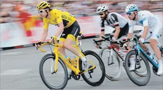  ?? LAURENT CIPRIANI
THE ASSOCIATED PRESS ?? Tour de France winner Britain’s Geraint Thomas, wearing the overall leader’s yellow jersey, Germany’s Simon Geschke and France’s Pierre Roger Latour, right, ride during the 21st stage of the Tour de France on Sunday.