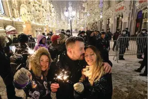  ?? The Associated Press ?? People celebrate the New Year in Nikolskaya street near an empty Red Square due to pandemic restrictio­ns during New Year celebratio­ns in Moscow on Saturday. Russia’s state coronaviru­s task force has registered a total of about 10.5 million confirmed infections and 308,860 deaths, but the state statistics agency that uses broader criteria in its tallying system has reported nearly 626,000 virus-linked deaths in Russia since the start of the pandemic.