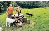  ?? FOTO: M. WIENZEK ?? Silke Bergmann mit den Ziegen Adelheid (vorn) und Kasimir. Im
Hintergrun­d flitzt Border Collie Jerry Lee über die Wiese.