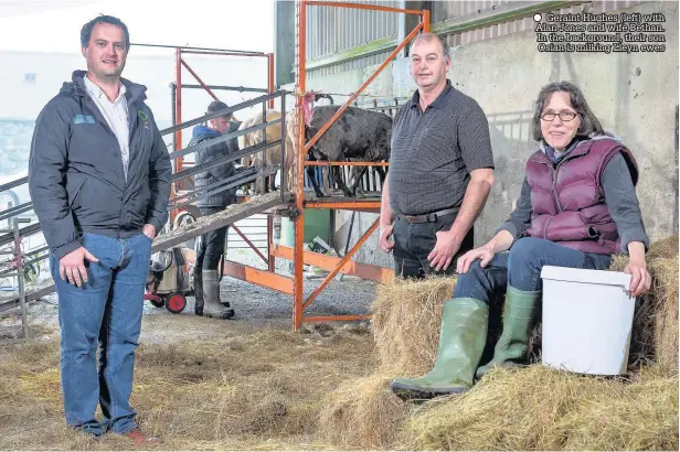  ??  ?? Geraint Hughes (left) with Alan Jones and wife Bethan. In the background, their son Osian is milking Lleyn ewes