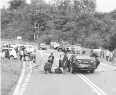  ??  ?? Members of the public helping the driver of the car.