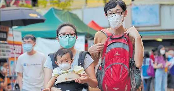  ?? Vincent yu/ap ?? Una pareja con su bebé colgado en Hong Kong