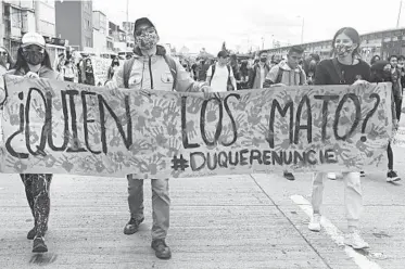  ?? FERNANDO VERGARA/AP PHOTOS ?? Students holding a poster that reads “Who killed them?” in Spanish march on Sept. 21 in Bogota, Colombia.