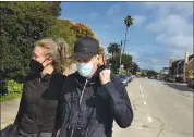  ??  ?? Photograph­er Jason Selman and his wife Jana Monello take their daily walk around the Seabright neighborho­od.