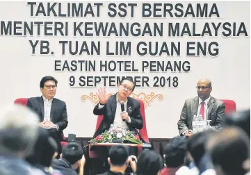  ?? — Bernama photo ?? Lim (centre) delivering his speech during the Sales and Services Tax briefing session. Subromania­m is at right.
