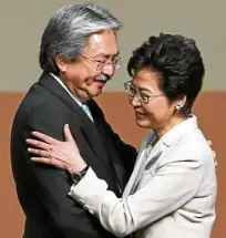  ?? —AP/AFP ?? HONGKONG POLLS Carrie Lam (left photo) is congratula­ted by rival John Tsang, after winning the chief executive position in Hong Kong’s elections, which prodemocra­cy activists (right) denounced as a sham.