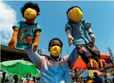  ?? AFP ?? RAISING AWARENESS: A puppeteer with his puppets wearing facemasks performs at a market to raise awareness among people on Covid-19 precaution­ary measures in Chennai on Wednesday. —