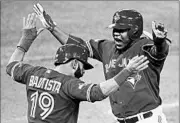  ?? DARREN CALABRESE/AP ?? Jose Bautista, left, and Edwin Encarnacio­n celebrate after scoring on Troy Tulowitzki’s bases-clearing double.