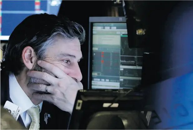  ?? RICHARD DREW / THE ASSOCIATED PRESS ?? Trader John Romolo grimly works the floor of the New York Stock Exchange during Thursday’s bad session.