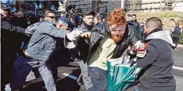  ??  ?? POLIS Israel menahan seorang penunjuk perasaan di luar Kementeria­n Pertahanan di Tel Aviv semalam ketika demonstras­i
menyokong Azaria. - AFP