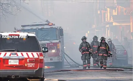  ?? BARRY GRAY THE HAMILTON SPECTATOR ?? Extra firefighte­rs were called in Monday afternoon to let crews rest and hydrate as the homes burned and to slow fire spreading to neighbours.