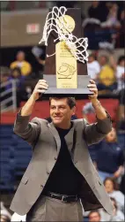  ?? Hearst Connecticu­t Media file photo ?? UConn coach Geno Auriemma holds up the NCAA Championsh­ip trophy in 2002.