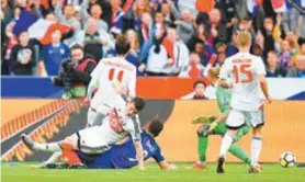  ??  ?? Giroud (caído) desloca o goleiro bielorruss­o para fazer o 2º da França