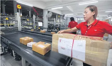  ?? THITI WANNAMONTH­A ?? Thailand Post employees process packages in Chon Buri.
