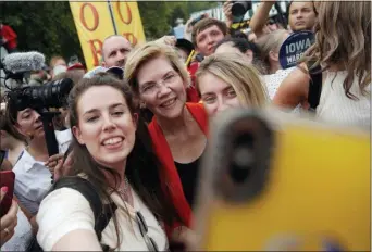  ?? JOHN LOCHER — THE ASSOCIATED PRESS ?? Democratic presidenti­al candidate Sen. Elizabeth Warren, D-Mass., poses for a selfie at the Iowa State Fair, Saturday in Des Moines, Iowa.