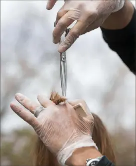  ?? Emily Matthews/Post-Gazette ?? Emilio Cornacchio­ne, an owner of Izzazu Salon, Spa and Blowout Bar, cuts and styles a mannequin’s hair outside his home in Scott on April 15.