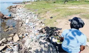  ?? PHOTOS BY RICARDO MAKYN/STAFF PHOTOGRAPH­ER ?? A woman reads her Bible next to garbage piled up along the beach adjacent to the Bournemout­h Bath, off Michael Manley Boulevard. Dr Homero Silva, who is a professor in public health, environmen­t, and climate change, is arguing that poor garbage...