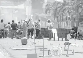  ?? AGENCE FRANCE PRESSE ?? Demonstrat­ors remain behind an improvised barricade during clashes with riot police during protests in Monimbo neighborho­od in Masaya, some 40km from Managua.