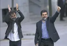  ?? Francisco Seco/Associated Press ?? Jordi Cuixart, president of the Catalan Omnium Cultural organizati­on, left, and Jordi Sanchez, president of the Catalan National Assembly, wave to supporters on arrival at the national court in Madrid on Monday.