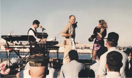  ?? Michelle Brown ?? Musicians Michelle Brown and Mark Lloyd give away a free T-shirt as they perform a two-hour concert for the US military on the ‘USS Portland’ in January, 1991. The ship was docked in Dubai