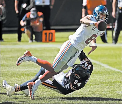  ?? JONATHAN DANIEL/GETTY IMAGES ?? Daniel Jones (8) gets off a pass as he is hit by Robert Quinn The Bears defeated the Giants 17-13 on Sunday after the Giants almost successful­ly rallied from a 17-0 deficit.