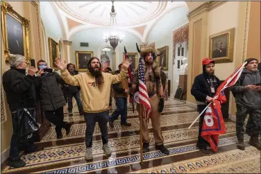  ?? (AP/Manuel Balce Ceneta) ?? Supporters of President Donald Trump are confronted by U.S. Capitol Police officers Wednesday outside the Senate Chamber inside the Capitol in Washington. Stories circulatin­g online incorrectl­y have asserted that Capitol rioters were antifa activists. At center is Jake Angeli, wearing a fur hat with horns. He is a regular at pro-Trump events and a known follower of QAnon.