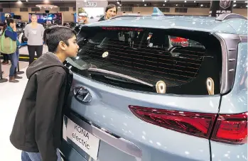  ?? RICHARD LAM/POSTMEDIA FILES ?? Nihaal Bhullar looks at an electric Hyundai Kona while visiting the 2018 Vancouver Internatio­nal Auto Show at the end of March.