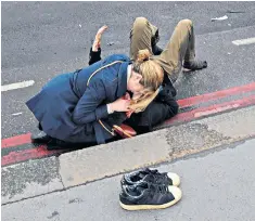  ??  ?? The touching image, left, of a woman cradling an injured man after the Westminste­r Bridge terror attack has been revealed to be Cara and Stephen Lockwood, right, a husband and wife from Oxfordshir­e