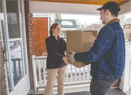  ?? PHOTOS: BRUCE DEACHMAN ?? Black Squirrel Books manager Joe Zador delivers books to Anne Louise Mahoney. She said it was “very exciting” to get the surprise box of book orders. Customers order boxes of their preferred genre from the shop online and wait “like Christmas” to see what they get.