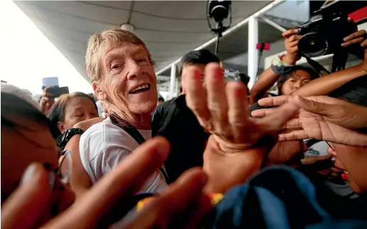  ?? AP ?? Australian Roman Catholic nun Sister Patricia Fox reaches out to bid goodbye to supporters as she is escorted to the Ninoy Aquino Internatio­nal Airport for her flight to Australia.