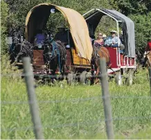  ??  ?? Participan­ts in the re-enactment of the March West rode in covered wagons on Friday from the hamlet of Josephburg to Fort Saskatchew­an.