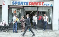  ?? — AFP ?? Pedestrian­s walk past the entrance of a Sports Direct store in central London.