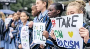  ??  ?? COLOUR-BLIND KIDS: Pupils from St Teresa’s School in Rosebank brave the rain and early morning traffic on Jan Smuts Avenue to take a stand against racism in South Africa.