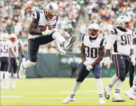  ?? Abbie Parr / Getty Images ?? Devin McCourty of the Patriots celebrates after intercepti­ng a pass from the Jets’ Josh McCown in the third quarter at MetLife Stadium on Sunday in East Rutherford, N.J. The Patriots won 24-17.