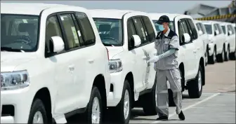  ?? LI RAN / XINHUA ?? A port employee checks vehicles imported from Japan at Tianjin Port.