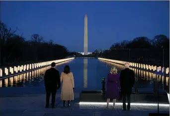  ?? EVAN VUCCI — AP ?? Above, with the Washington Monument in the background, President-elect Joe Biden with his wife Jill Biden and Vice Presidente­lect Kamala Harris with her husband Doug Emhoff listen as Yolanda Adams sings “Hallelujah” during a
COVID-19 memorial, with lights placed around the Lincoln Memorial Reflecting Pool, Tuesday, Jan. 19,
2021, in Washington.
At left, a field of flags is spread across the
National Mall, with the Washington Monument in the background on Tuesday, Jan. 19, 2021, as seen from the West Front of the U.S. Capitol on the evening ahead of the 59th Presidenti­al Inaugurati­on in Washington.